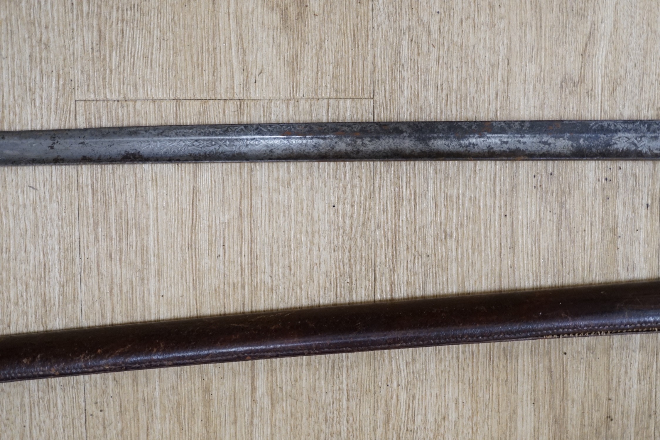 A George V dress sword, in a leather scabbard, 108cm long